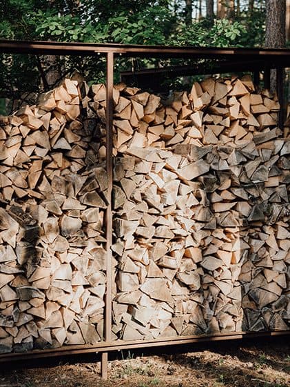 Stacked wood in a Corten steel rack on the company grounds