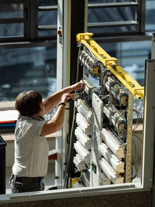 Technician assembling a frame with a standardised electrical distribution board