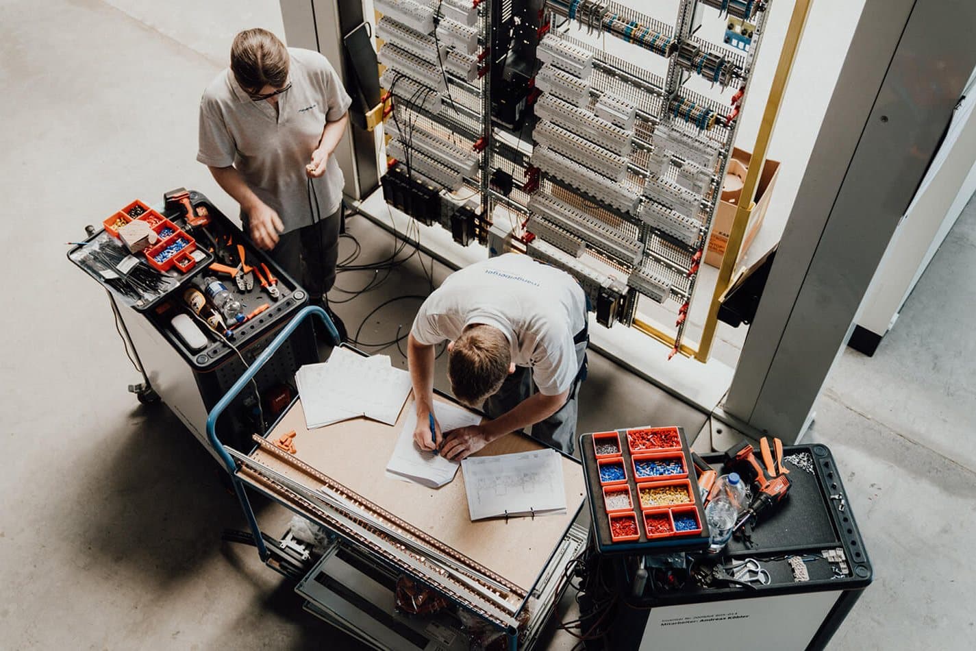 Two fitters wiring a switch cabinet based on a proven basic concept